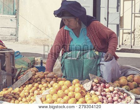 HUARAZ, PERU - JULY 27: Traditionally dressed peruvian people sell fruits and vegetables on the street market on July 27, 2017 in Huaraz, Peru.