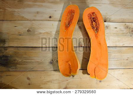 Pumpkin Butternat Squash Cut Lengthwise On A Plank Table.