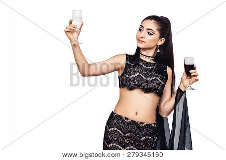 Young Gorgeous Girl Holds A Glass Of Wine And Champagne In Her Hands And Chooses. Isolated On White