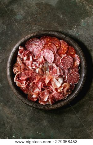 Antipasto Meat Platter Assorti Of Sliced Jamon, Salami, Chorizo Sausage In Terracotta Tray Over Dark