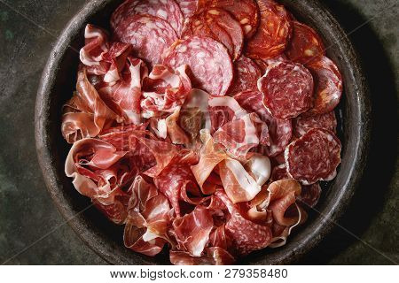 Antipasto Meat Platter Assorti Of Sliced Jamon, Salami, Chorizo Sausage In Terracotta Tray Over Dark