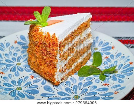 Carrot Cake With Butter Cream Served Garnished With Mint On A Plate