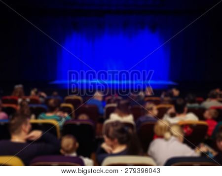 Blurred Abstract Image. Auditorium Of The Theater.  Parents With Children Before The Show. Blue Curt