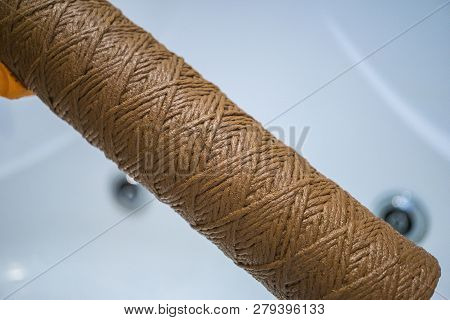 Hand Holding Dirty Water Filter Cartridge Over The Bathhub