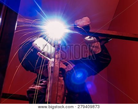 Welder Worker Performs Jump Welding. Worker Welder Performs Arc-welding Process Of Metal Structures.