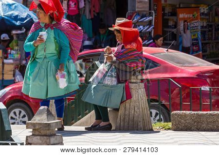 HUARAZ, PERU - JULY 27: Traditionally dressed peruvian people sell fruits and vegetables on the street market on July 27, 2017 in Huaraz, Peru.