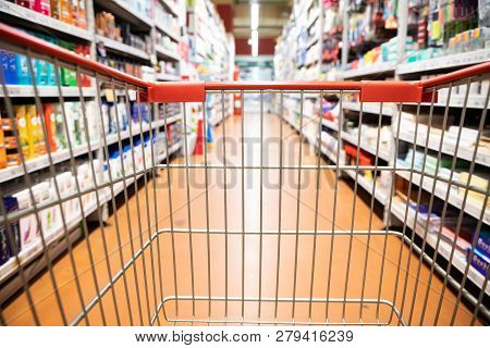 Perspective View Shopping Trolley Cart With Supermarket Aisle Blurred Background