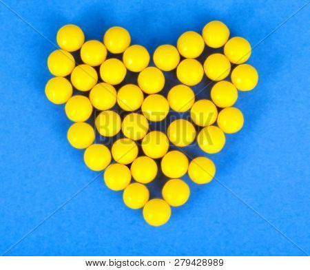 Small Medical Pharmaceptic Round Yellow Pills, Vitamins, Drugs, Antibiotics In The Form Of A Heart O
