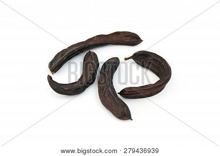 Locust Bean On A White Background,
Carob On A Plate, On A White Background