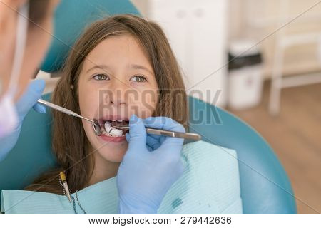 Teeth Checkup At Dentists Office. Little Girl At The Reception In The Dentists Office. Little Girl S