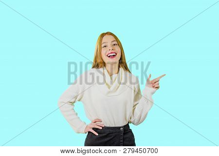 A Beautiful Girl With Red Hair Smiles With A Smirk, Throwing Her Head Back And Shows With Her Index 