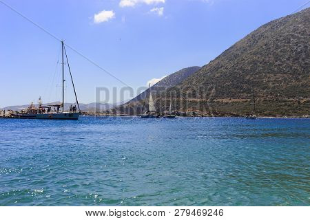 White Sailboat In The Open Mediterranean Sea On A Sunny Day. Sailing Yacht In The Open Sea With Moun