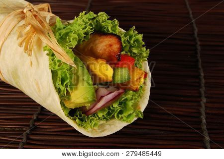 Marinated Chicken With Avocado Wrap Sandwich On Wooden Woven Mat