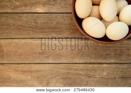 Egg In Dish On Old Wooden Table Background, Top View