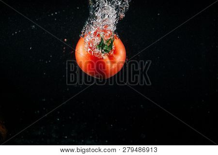 Fresh Large Tomato Falls In Water And Makes Bubbles