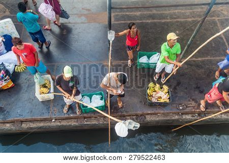 Juruti, Brazil - June 28, 2015: Sellers Use A Long Stick To Deliver The Goods To Passengers Of A Riv