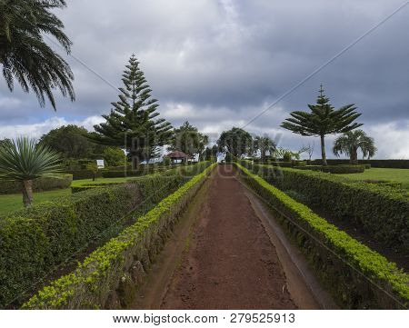 Dirt Footpath In Gardens At Viewpoint Ponta Do Sossego With Green Bush, Palm Trees And Altan Gazebo,