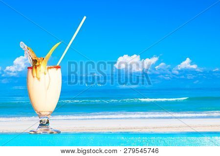 Refreshing Pina Colada Cocktail Against Water Oceam And Amazing Beach Background. Summer Vacation Co