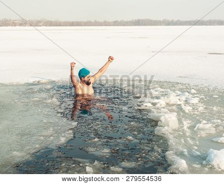 Bearded Man In Hat In Ice Hole Swimming