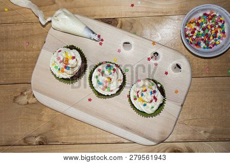 Muffins On A Wood Cutting Board. Cream Decoration. Place For Text. View From Above
