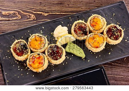 Top Closeup View On Sushi Rolls. Eight Roll Pieces And Side Dish.
