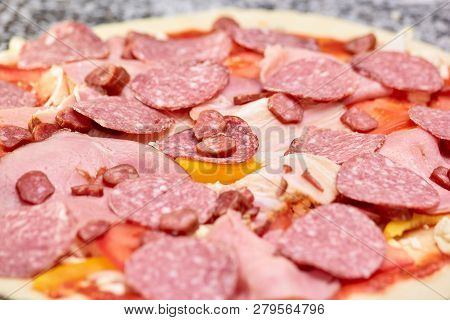 Closeup Spicy Salami Pizza Before Baking. Large Amound Of Salami And Hams On Pizza Dough.