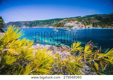 Amazing Assos Village, Kefalonia. Greece. White Cruise Yachts Staying At Anchor In Beautiful Emerald
