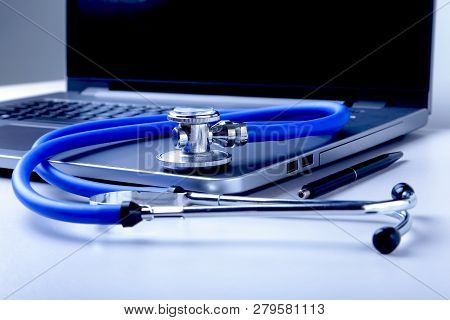 Workplace Of Doctor With Laptop, Stethoscope And Rx Prescription On White Table. Top View.