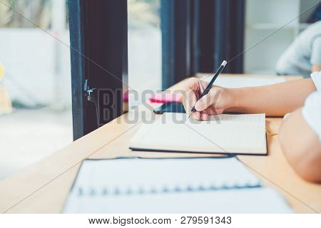 High School Or College Students Studying And Reading Together In Library