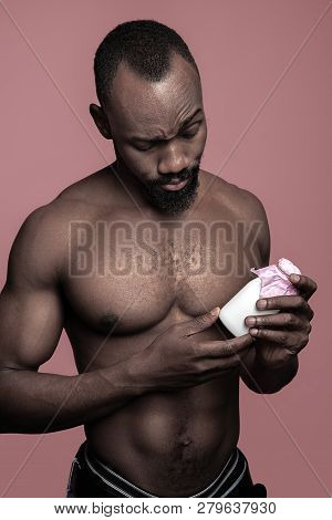 Healthy Young African Man Holging Little Bottle Of Milk On A Pink Studio Background. Close Up Portra