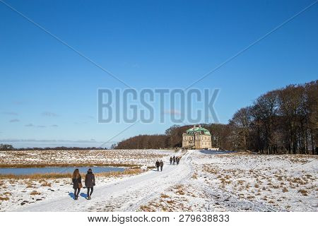 Klampenborg, Denmark - February 12, 2017: The Hunting Lodge And People Walking In The Snowy Deer Par