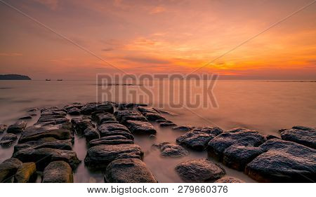 Rocks On Stone Beach At Sunset. Beautiful Beach Sunset Sky. Twilight Sea And Sky. Tropical Sea At Du