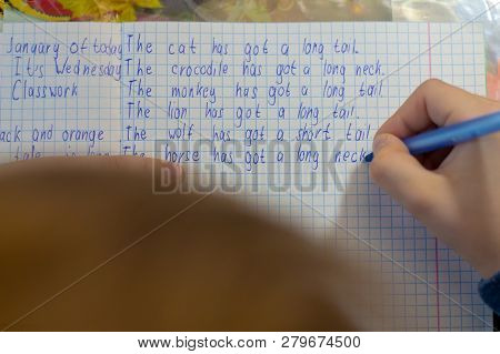 Home Education And Work After School. Boy Hand With Pen Writing English Test By Hand On Traditional 