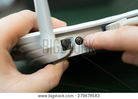 Man Pressing Power Button On The Wifi Router.