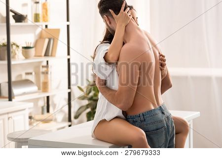 Selective Focus Of Sexy Couple Passionately Hugging At Kitchen Counter At Home