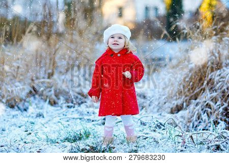 Outdoor Winter Portrait Of Little Cute Toddler Girl In Red Coat And White Fashion Hat Barret. Health