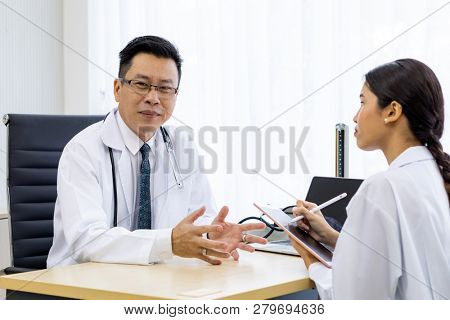 Two doctors in the hospital discuss the diagnos of the patient