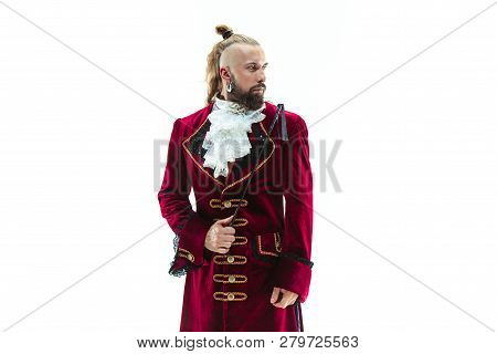 The Young Man Wearing A Traditional Medieval Costume Of Marquis Posing At Studio With Whip. Fantasy,