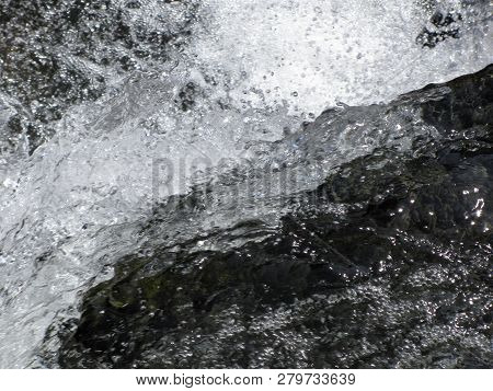 Water Flowing And Splashing Over Rocks Background