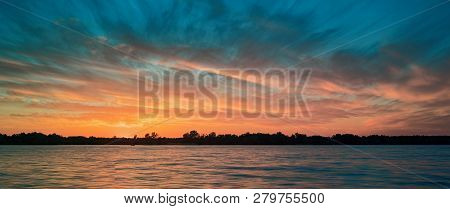 River Sunset On The Background Of The Shore And Clouds.