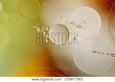 Macro Shot Of Backlit Water-oil Emulsion Over Colored Background. Tiny Gas Bubbles Inside Larger Oil