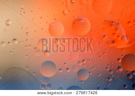 Macro Shot Of Backlit Water-oil Emulsion Over Colored Background. Tiny Gas Bubbles Inside Larger Oil
