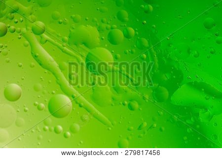 Macro Shot Of Backlit Water-oil Emulsion Over Colored Background. Tiny Gas Bubbles Inside Larger Oil