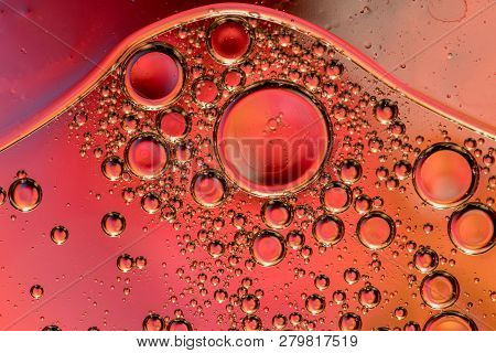Macro Shot Of Backlit Gas-liquid Emulsion Over Colored Background. Gas Bubbles Inside Larger Oil Bas