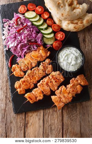 Close-up Of Chicken Skewers With Fresh Salad, Yogurt Sauce And Pita Bread On A Slate. Vertical Top V