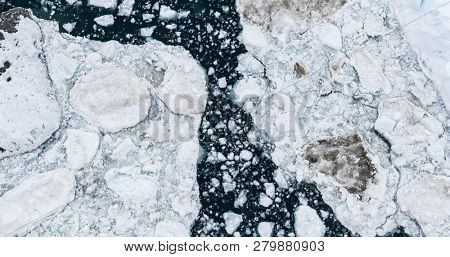 Icebergs drone aerial image top view - Climate Change and Global Warming. Icebergs from melting glacier in icefjord in Ilulissat, Greenland. Arctic nature ice landscape in Unesco World Heritage Site.