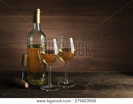 Bottle Of White Wine With Wine Glasses On Wooden Background
