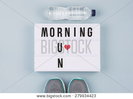 Motivation Text On Light Box Morning Run And Sports Accessories: Running Shoes And Bottle Of Water O
