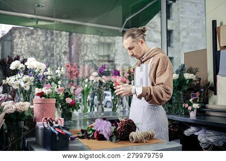 Attentive Blonde Male Person Composing Unordinary Bouquet