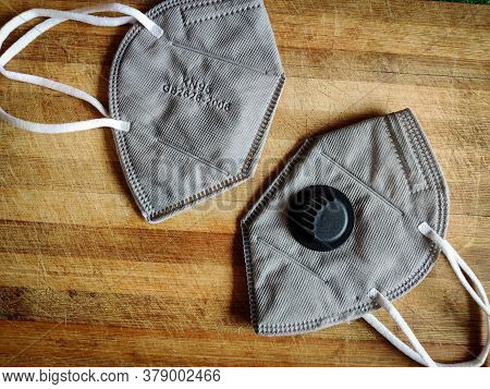 Two Grey Color Kn-95 Face Mask Isolated On Wooden Board. Protection From Corona Virus Or Covid-19. W